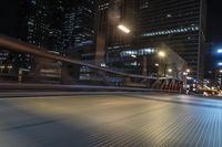 the blurry shot of an empty street at night shows off many tall buildings and buildings