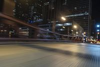 the blurry shot of an empty street at night shows off many tall buildings and buildings