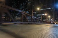 the blurry shot of an empty street at night shows off many tall buildings and buildings