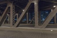 traffic passes under a highway at night as it sits empty on the pavement and looks out towards the city