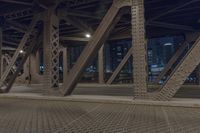 traffic passes under a highway at night as it sits empty on the pavement and looks out towards the city