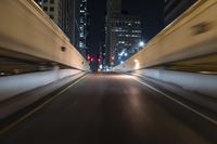 the car is driving over the bridge at night in traffic lights, traffic, skyscrapers, cars