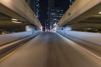 the car is driving over the bridge at night in traffic lights, traffic, skyscrapers, cars