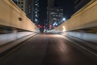 the car is driving over the bridge at night in traffic lights, traffic, skyscrapers, cars