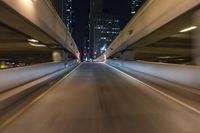 the car is driving over the bridge at night in traffic lights, traffic, skyscrapers, cars