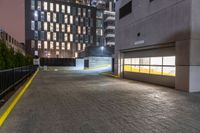 a fire hydrant sits in the center of a parking lot by a high rise building with two floors