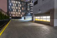 a fire hydrant sits in the center of a parking lot by a high rise building with two floors