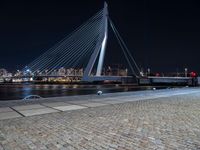 a city lit up at night and lit up by lights, with a bridge spanning across it