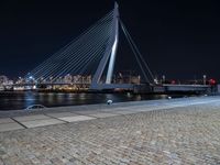 a city lit up at night and lit up by lights, with a bridge spanning across it