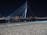 a city lit up at night and lit up by lights, with a bridge spanning across it