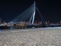 a city lit up at night and lit up by lights, with a bridge spanning across it