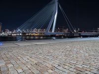 a city lit up at night and lit up by lights, with a bridge spanning across it