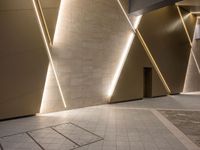 a hallway with columns on the wall that have led lights coming out of them and a door is behind the wall