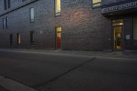 a building with a red door on the side of it is empty and lit up