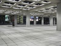 a large empty square on the outside of a building at night time with many windows