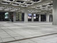 a large empty square on the outside of a building at night time with many windows