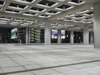 a large empty square on the outside of a building at night time with many windows