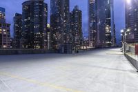 a large parking lot in a city next to tall buildings at night in the dark