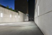 the large concrete wall has been illuminated by recessed lights at night on either side of it