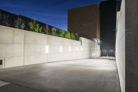 the large concrete wall has been illuminated by recessed lights at night on either side of it