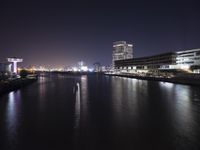 a long exposure photograph of the skyline at night with the lights on and reflection on the water