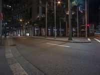 a street with no cars on a busy street at night, and the lights are on