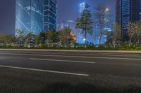 a city street with buildings and neon lights at night time in hong china as seen from an empty city highway