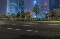 a city street with buildings and neon lights at night time in hong china as seen from an empty city highway