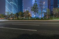 a city street with buildings and neon lights at night time in hong china as seen from an empty city highway