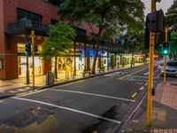 the street is busy with stores on both sides of it at nighttime on a quiet city street