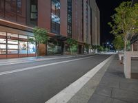 a night scene of an empty street in front of an office building and business center