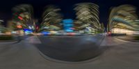 a city view with the blurred streets and traffic lights at night time as seen from inside a fisheye lens