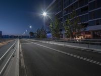 a view of the street where i can see the buildings in the background at night