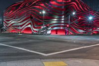 an american flag building with red and silver lights at night in a city street or street corner