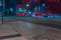 an american flag building with red and silver lights at night in a city street or street corner