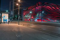 an american flag building with red and silver lights at night in a city street or street corner