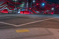 an american flag building with red and silver lights at night in a city street or street corner
