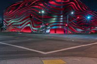 an american flag building with red and silver lights at night in a city street or street corner