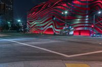 an american flag building with red and silver lights at night in a city street or street corner