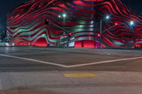 an american flag building with red and silver lights at night in a city street or street corner