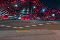 an american flag building with red and silver lights at night in a city street or street corner