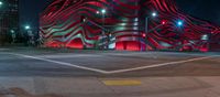 an american flag building with red and silver lights at night in a city street or street corner