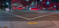 an american flag building with red and silver lights at night in a city street or street corner