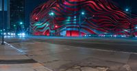 an american flag building with red and silver lights at night in a city street or street corner