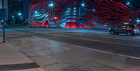 an american flag building with red and silver lights at night in a city street or street corner