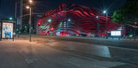 an american flag building with red and silver lights at night in a city street or street corner