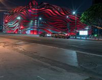 an american flag building with red and silver lights at night in a city street or street corner