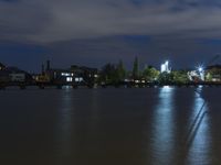 a night time photo shows the skyline as well as the water and building lights in the background