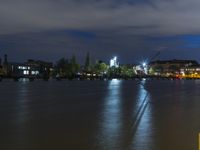 a night time photo shows the skyline as well as the water and building lights in the background