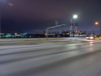 a blurry image of the highway in night time with lights reflecting off of the asphalt